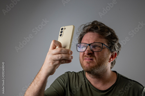 Cuadro en lienzo Frustrated Man Struggling to Read Mobile Phone
