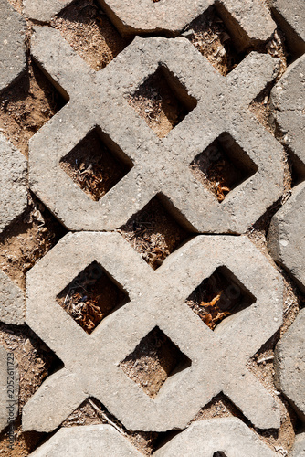 Close up of a concrete fence with large grid pattern, textured industrial wall structure.