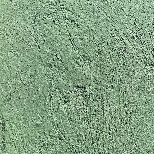 Green textured stucco wall surface close up with rough plaster finish