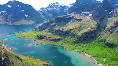 Aerial drone view of Lofoten Islands in Norway, featuring beautiful landscapes on Vindstad Beach near Reine, white sand clear water and dramatic mountains near the shore. Experience the natural beauty