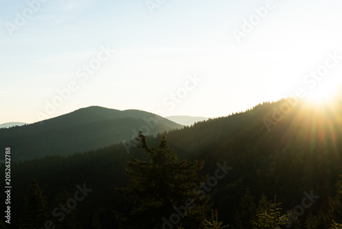  golden hour Sunrise In The Mountains With Silhouettes Of Peaks In The Rays Of The Setting Sun, Scenic Mountain Landscape In Yellow Red And Pink Hues, Evening Nature Background