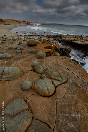 Foto Earth's ancient sculpture garden — an extraordinary field of perfectly rounded concretion boulders emerges from eroded sandstone platforms along the wild, desolate coastline of Lobitos, Piura, Peru