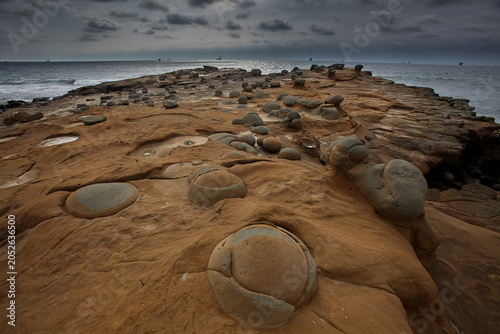 Obraz na plátně Earth's ancient sculpture garden — an extraordinary field of perfectly rounded concretion boulders emerges from eroded sandstone platforms along the wild, desolate coastline of Lobitos, Piura, Peru