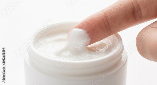 Foto A close-up of a person's finger touching a smooth white cosmetic face cream