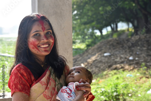 Loving mother hugs her little baby at home,Happy, cheerful ethnic mom holds a laughing baby daughter in her arms. Indian mother and baby portrait.