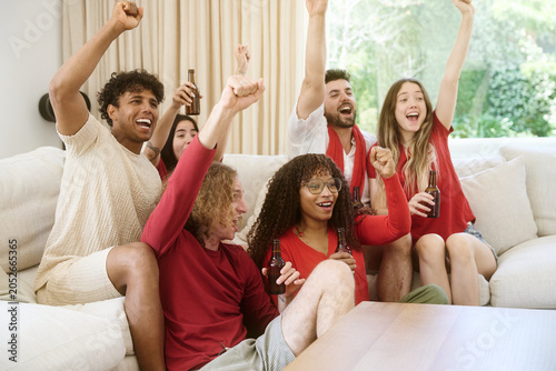 Obraz na płótnie Diverse friends watching game and celebrating goal at home