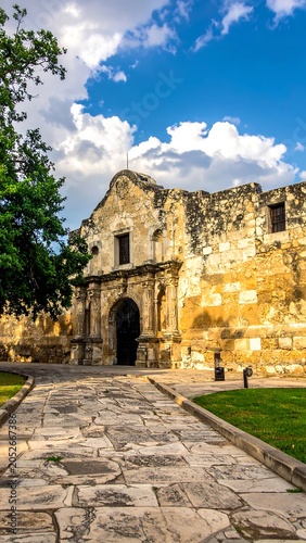 A historic stone building with an arched entrance and pathway leading to it