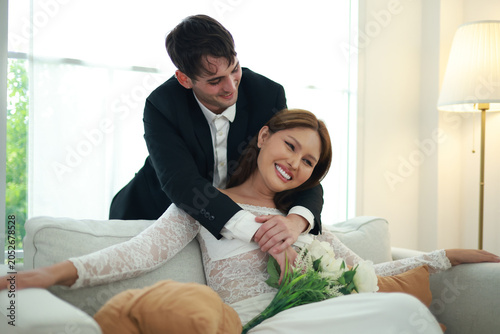 Vászonkép Married couple sits affectionately expressing their love and goodwill towards each other transgender woman and handsome foreign man sit holding hands gently demonstrating equality