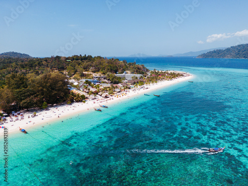 Aerial Drone View of Koh Lipe Island. Long tail Boat with tourists on the turquoise water.  Thailand