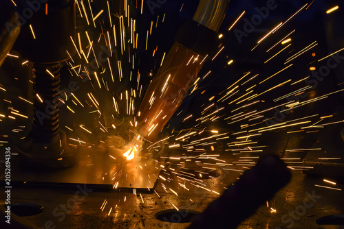Close-up of sparkling light and bright sparks during an industrial high-precision laser welding process.