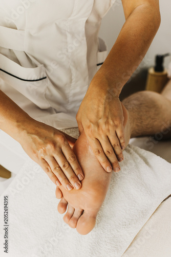 Close up of leg massage therapy session. Female massage therapist's hands.