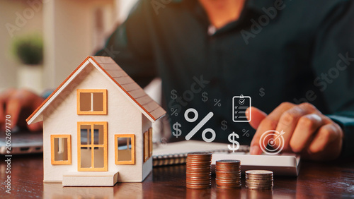 House model, stacked coins, calculator, and interest rate symbols illustrate mortgage planning, home loans, property investment, financial management, refinancing, and real estate wealth growth.
