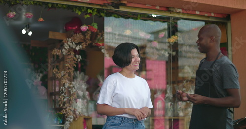 Fotografie Two shop owners talking in front of flower store, smiling and engaged in friendl