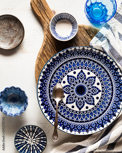 Vibrant blue decorative dishes on and around a wooden cutting board.