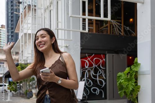 Bild auf Leinwand happy-woman-greeting-during-video-call-outdoors