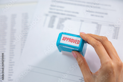 Approval stamp document hand paper finance business office contract application approval stamp pressed by hand blurred financial document, showing review, authorization, certification, compliance