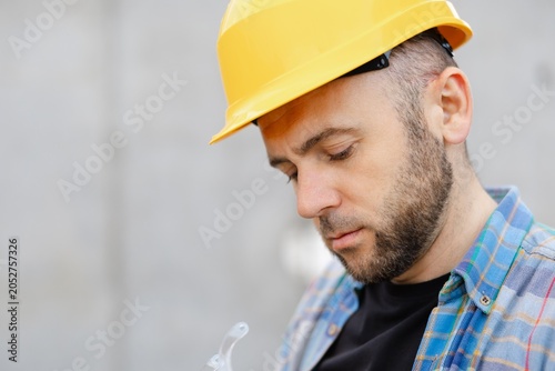Construction worker wearing hard hat looking down, concentrating