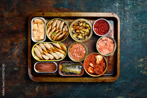 cans canned with different types of fish and seafood: fish, caviar, cod liver, sprats. Top view