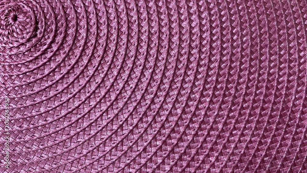 Fototapeta premium A purple woven texture with a detailed and symmetrical spiral pattern. Featuring a tightly woven, decorative grain, it's perfect for use as a background or design element in crafts.