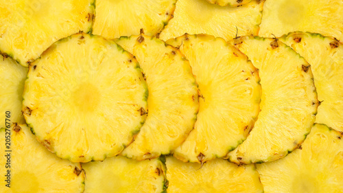 Pineapple background. Yellow juicy slices of ripe pineapple. Close-up, macro photo.