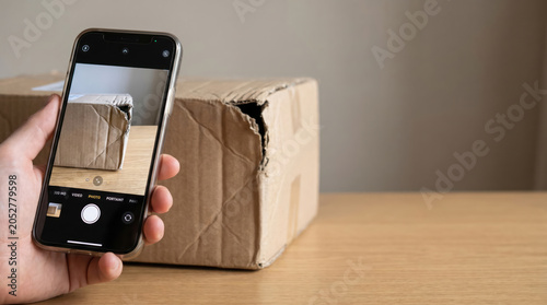 Customer Documenting Damaged Package with Smartphone for Shipping Claim