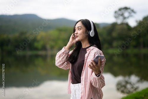 Young Asian woman enjoying outdoor music with headphones