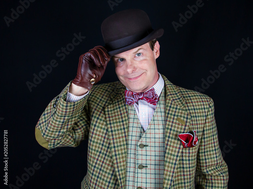 Bild auf Leinwand British Gentleman in Tweed Suit and Leather Gloves Doffing Bowler Hat in Polite Greeting