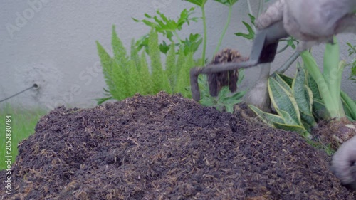 Mixing soil with fertilizer using a hand shovel and a hand fork close up, agriculture.