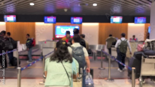 Passengers queue to board a plane at the airport terminal. Blur video.	