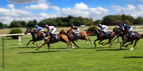 Fotografie Exciting horse race with jockeys competing at full speed on a racetrack
