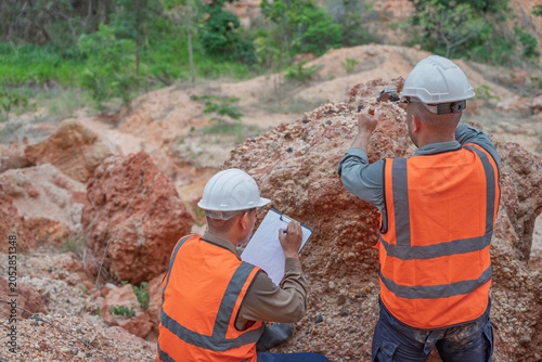 Photos Two professional geologists team up for fieldwork, carefully examining mineral rocks and collecting soil samples to survey the mine site for geological research and industrial exploration