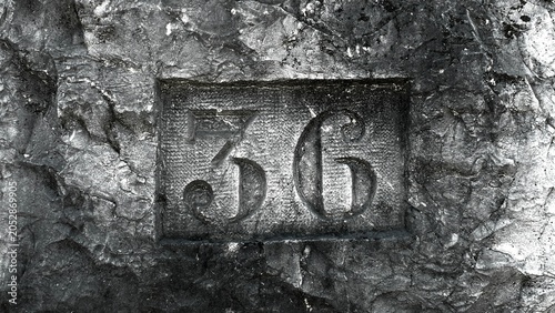 Fotografie Engraving 36 number into rough stone texture