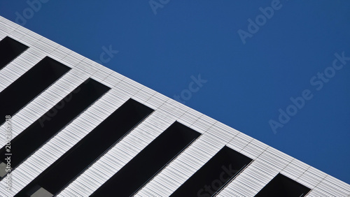 Building facade with diagonal lines against blue sky