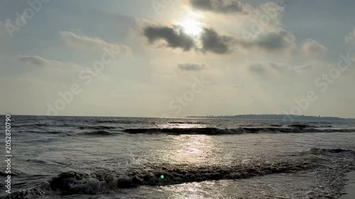 Beautiful golden sunlight reflecting on sea waves under cloudy sky