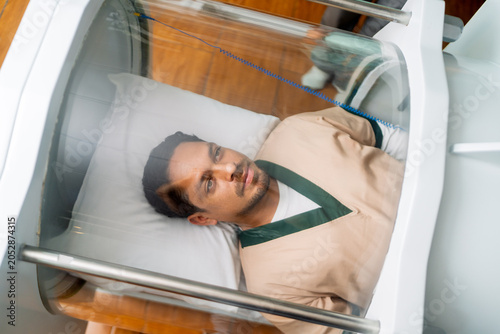 Young man receiving hyperbaric oxygen therapy treatment