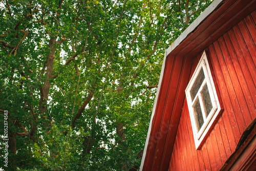 Bild auf Leinwand red wooden house gable with oak tree and countryside atmosphere