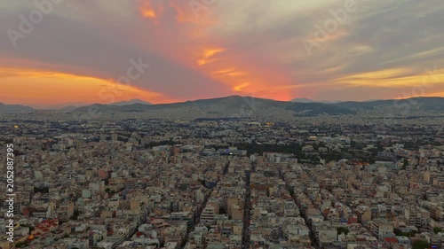 Golden hour sunset casting warm light over the sprawling cityscape of athens, greece, with picturesque mountains on the horizon creating a stunning panoramic and scenic urban landscape