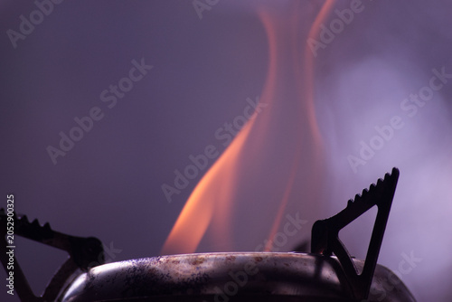 Foto Well used Portable wood stove burning wood with a large red flame erupting out from within the chamber
