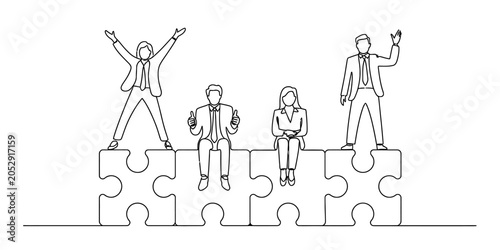 Fotografie Business team sitting and standing on puzzle pieces, one person with arms raised