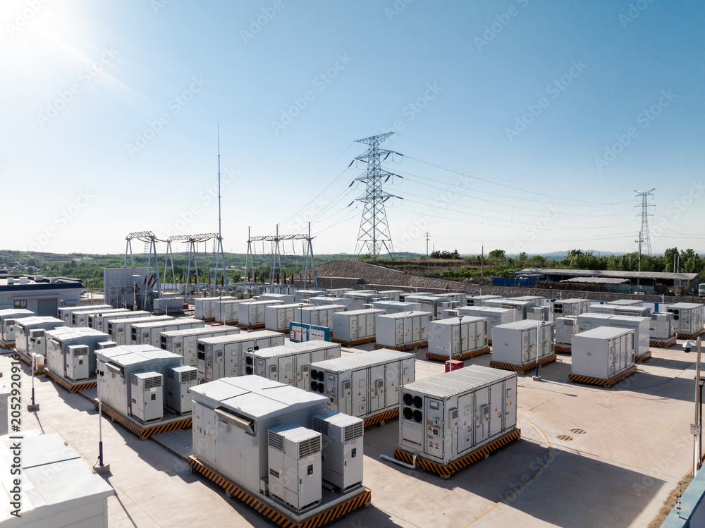 Fototapeta premium outdoor energy storage power station equipment with high voltage transmission towers under blue sky