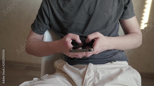 A young man is completely immersed in correspondence with friends
