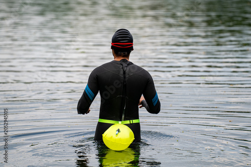 Canvastavla Open water swimmer preparing for a swim in a lake.