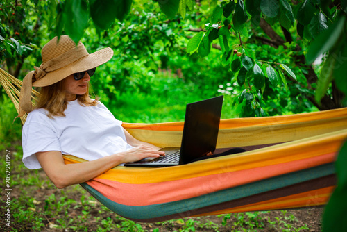 Tableau sur toile Young woman using laptop outdoor