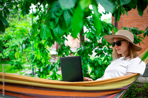Photos Young woman using laptop outdoor