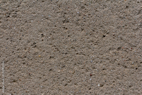 Rough concrete wall texture with small pebbles and weathered surface for back...
