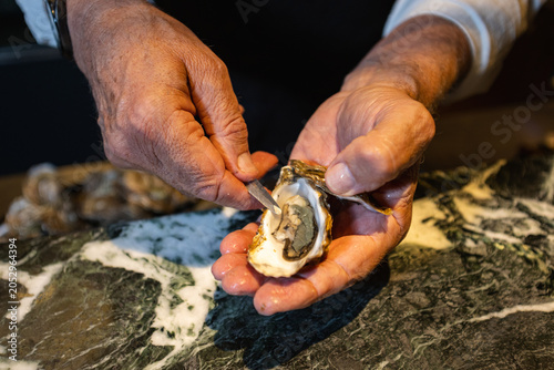 Fotografija Close-up of a Chef Shucking Fresh Oyster with a Shucking Knife