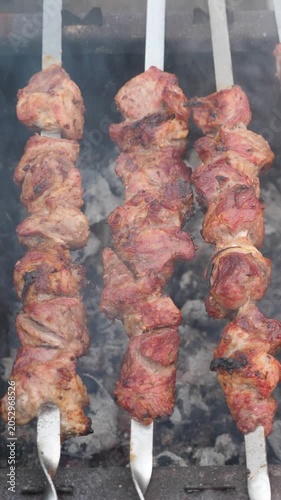 Grilling pork kebab on skewers at bbq, cooking process. Vertical footage
