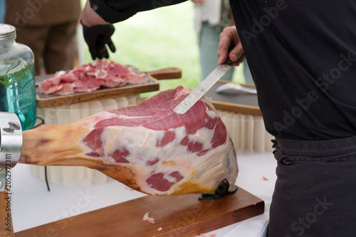 Découpe artisanale de jambon cru sur support traditionnel – gastronomie et savoir-faire
