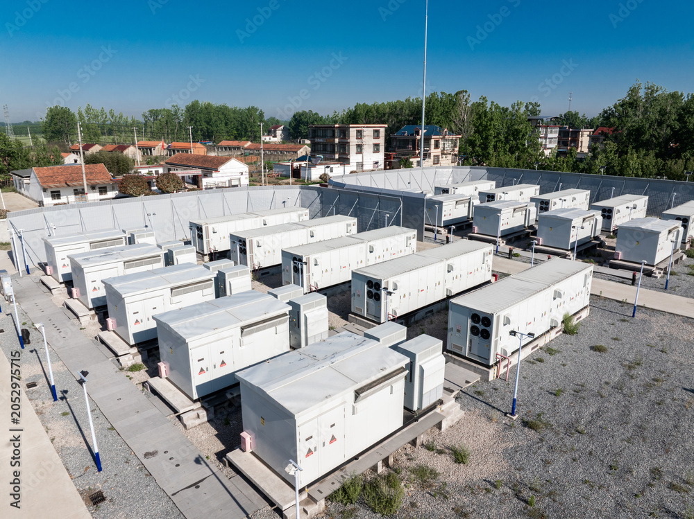 Fototapeta premium outdoor energy storage power station with rows of white container units under blue sky