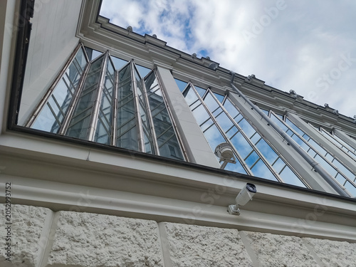 Clean windows of a modern style design building with blue sky reflections in the glasses. Day sun clear light